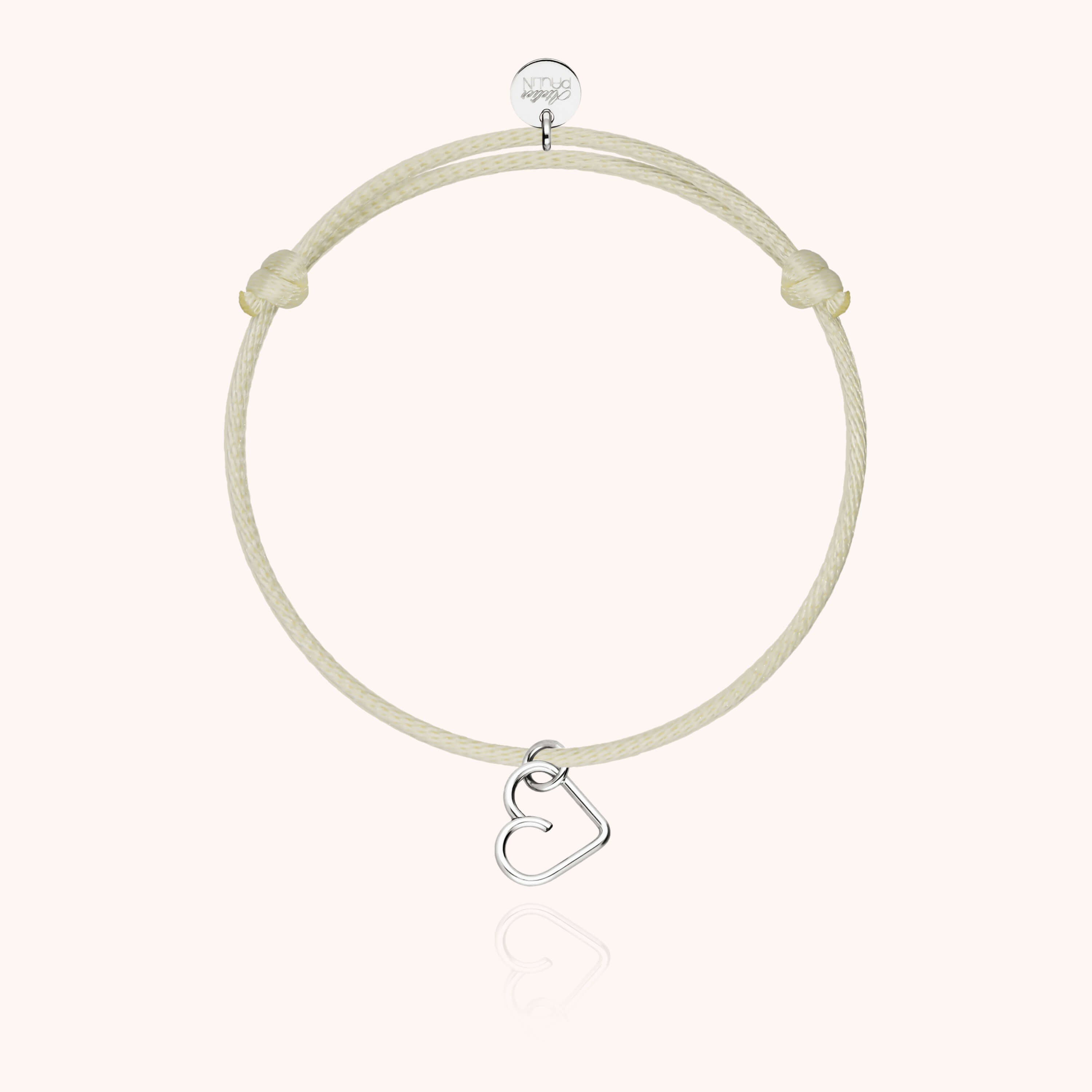 Bracelet cordon enfant porté au poignet avec charm cœur or blanc
